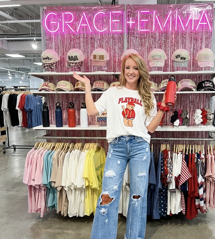 Post showing a graphic tee in front of a wall of hats and tees
